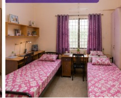 Double sharing room at Sairam Ladies Hostel with twin beds and study desks