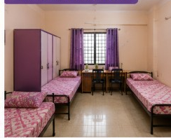 Triple sharing room at Sairam Ladies Hostel with three beds and wardrobes